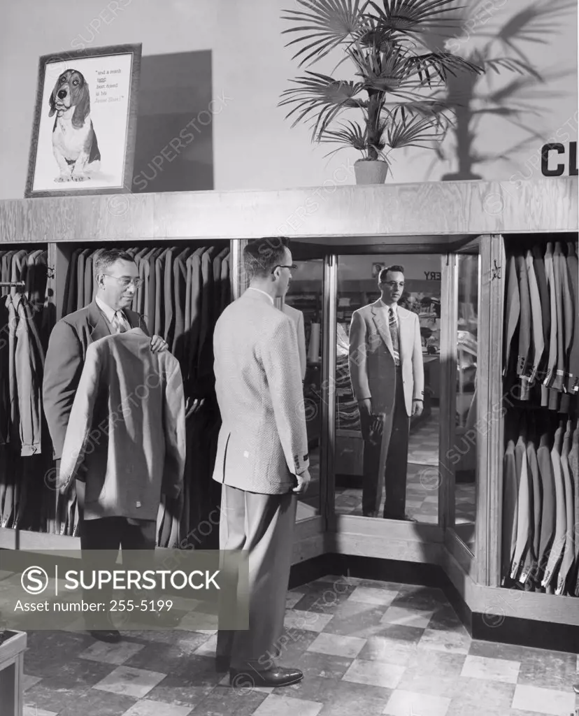 Young man trying suit in clothing store
