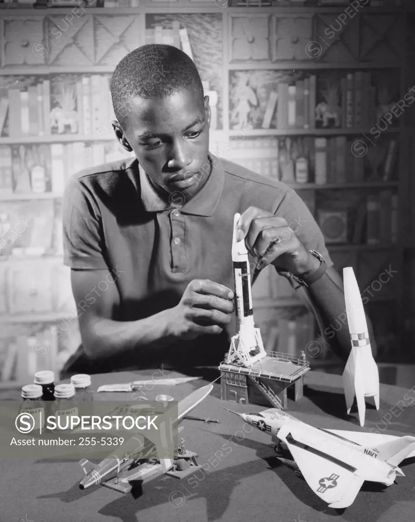 Teenage boy making a model rocket, 1964