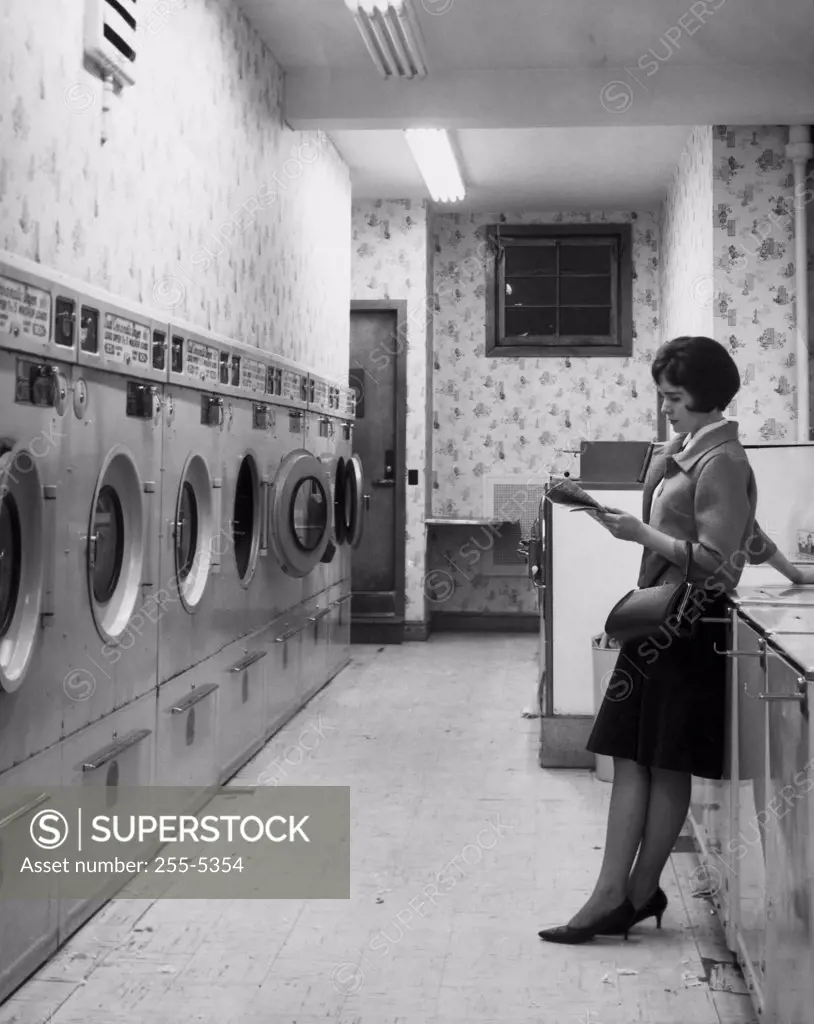 Side profile of young woman standing in laundromat