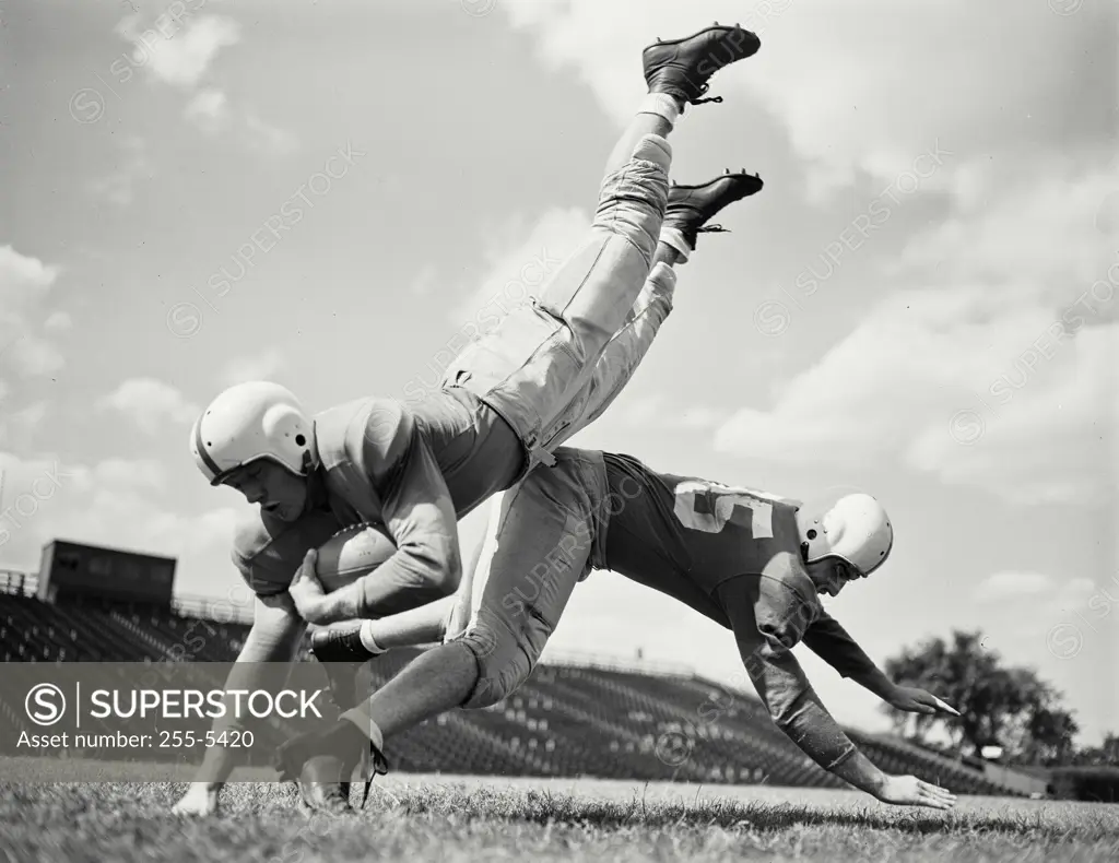 Vintage photograph. Football players - player tackling player with ball.