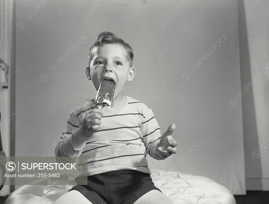 Vintage photograph. Close-up of a boy eating an ice cream