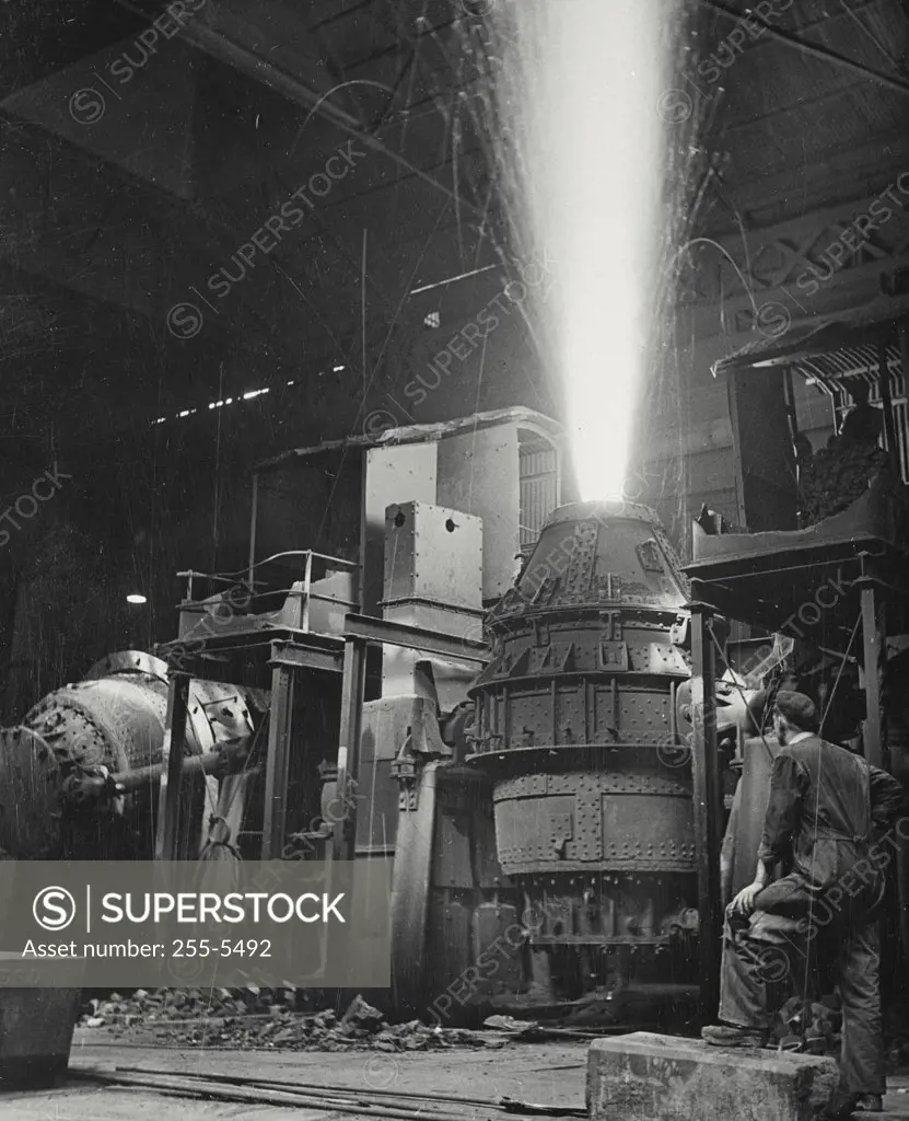 Vintage photograph. A Bessemer converter blowing off at British steel factory. Molten iron is pouring into this converter, manganese or other metals added in small quantities and air is blown through the mass to remove carbon.