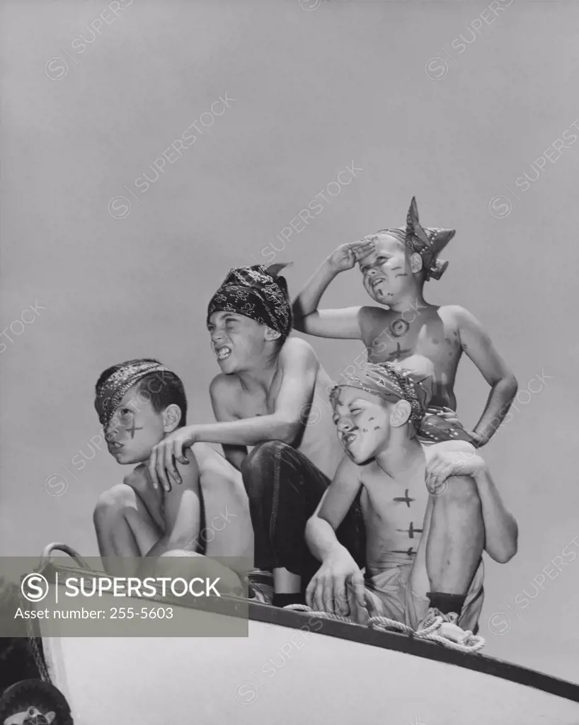 Four boys sitting on a boat and pretending to be pirates