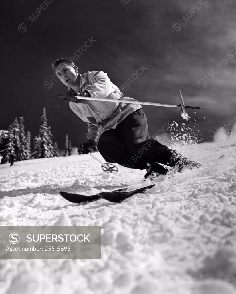 Low angle view of a young man skiing downhill