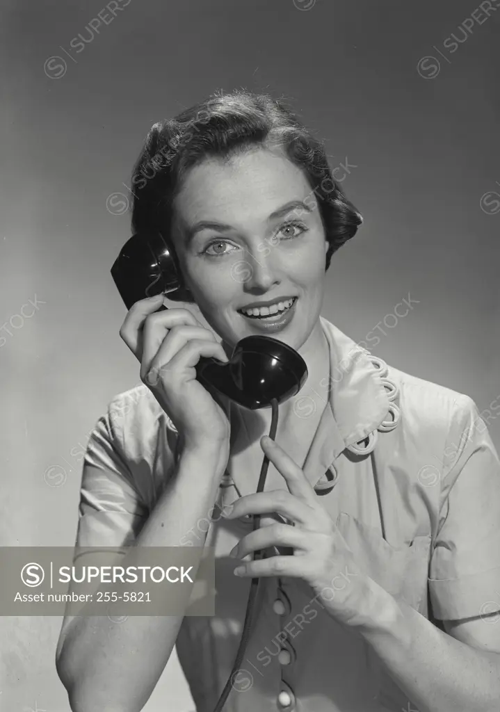 Vintage Photograph. Young woman in button blouse on telephone.
