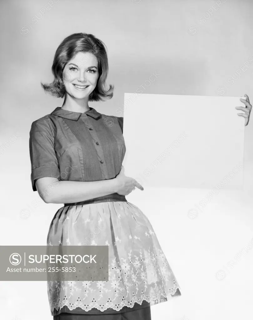 Portrait of a young woman holding a blank placard