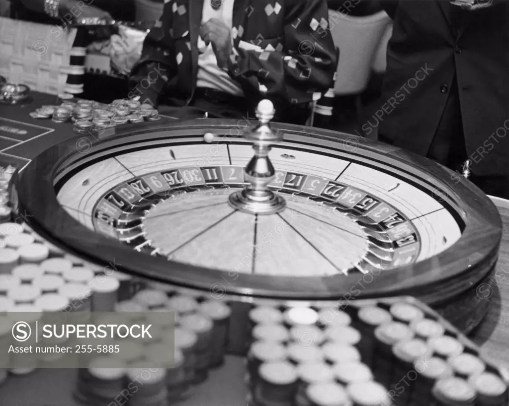 Close-up of roulette wheel with gambling chips in casino