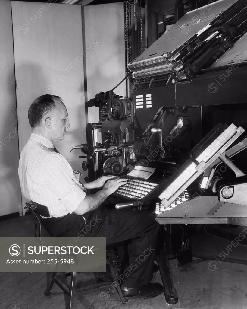 Side profile of a male worker operating a linotype machine