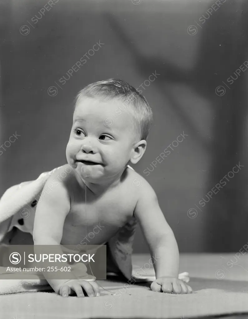 Vintage Photograph. Shirtless baby drooling and leaning on hands