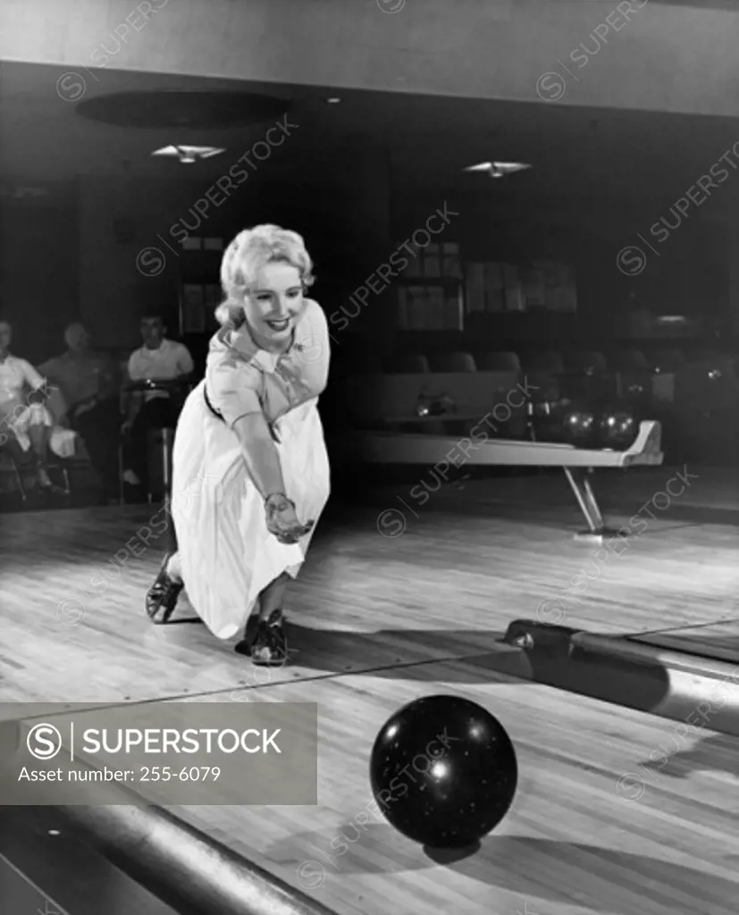 Young adult woman bowling