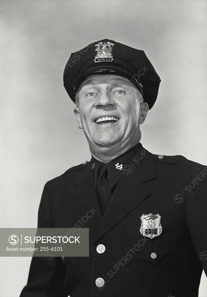 Man in police uniform with exaggerated smile.