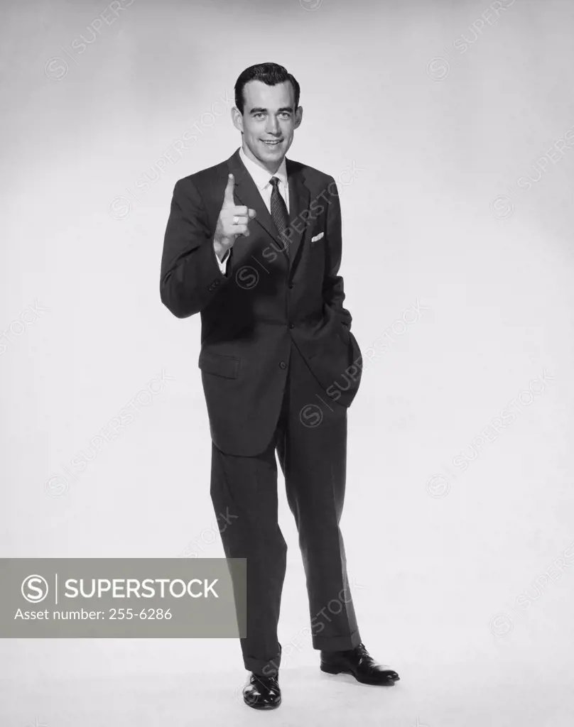 Portrait of businessman pointing upwards