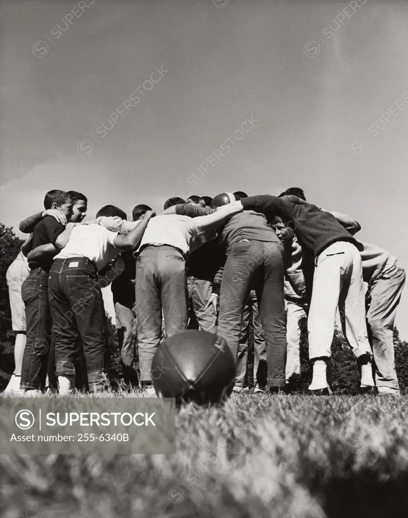 Rear view of football players in a huddle