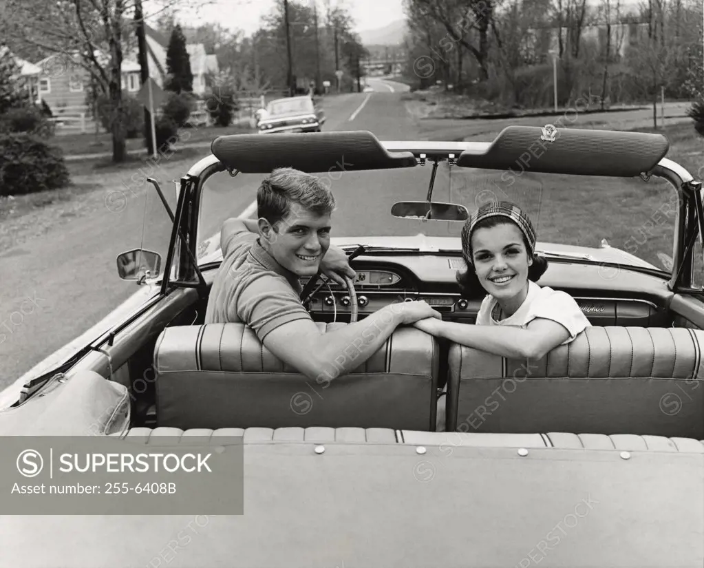 Portrait of a young couple sitting in a convertible car