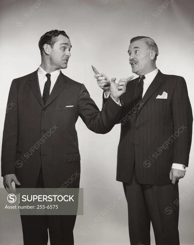 Two businessmen pointing at each other