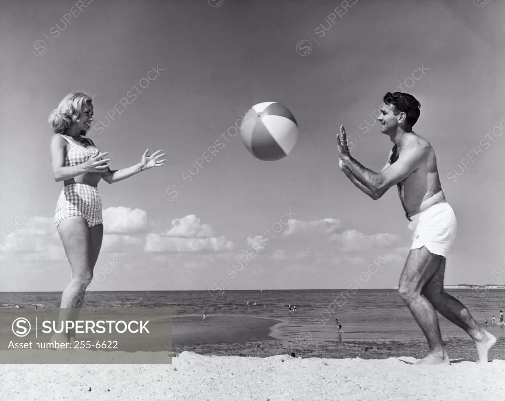Young couple playing with beach ball on beach