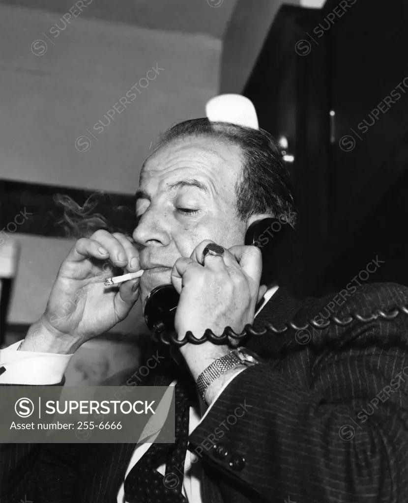 Man with cigarette talking on phone