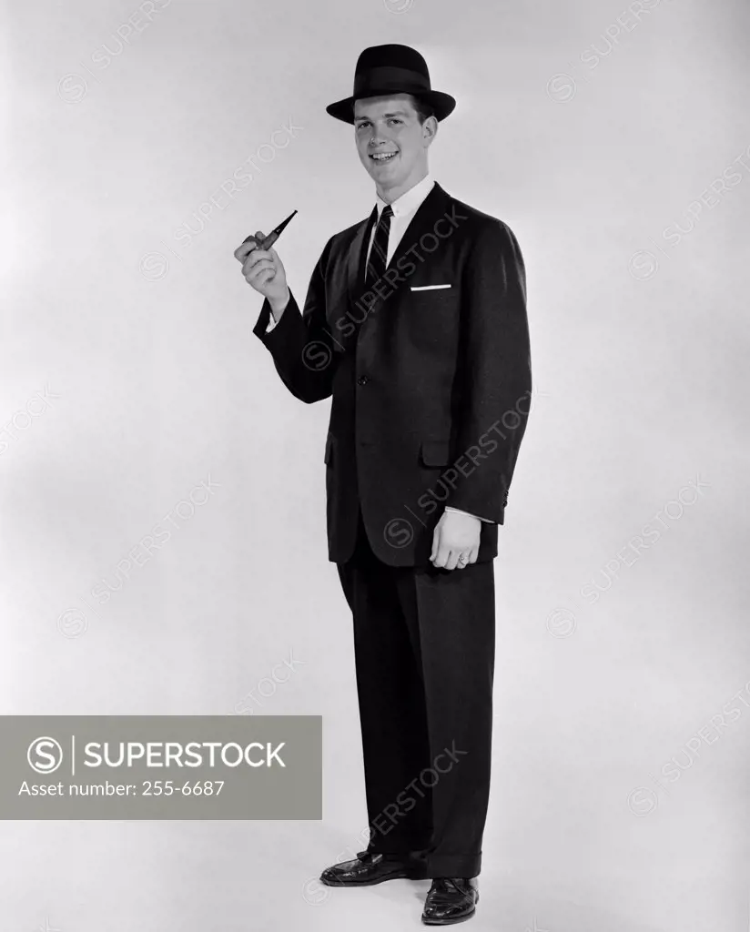 Studio portrait of smiling man with pipe