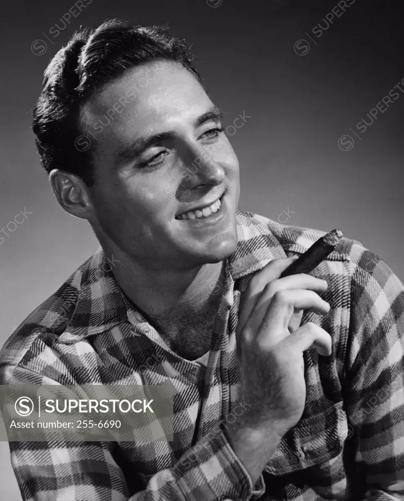 Vintage Photograph. Man in flannel shirt holding cigar and smiling