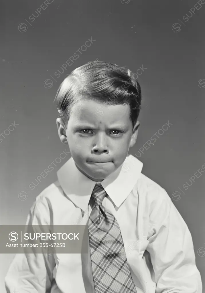 Vintage Photograph. Young boy wearing dress shirt and tie with serious expression
