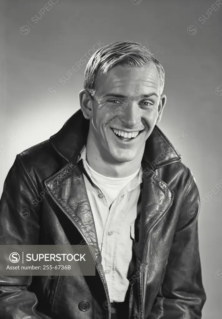 Vintage Photograph. Man wearing leather biker jacket smiling at camera