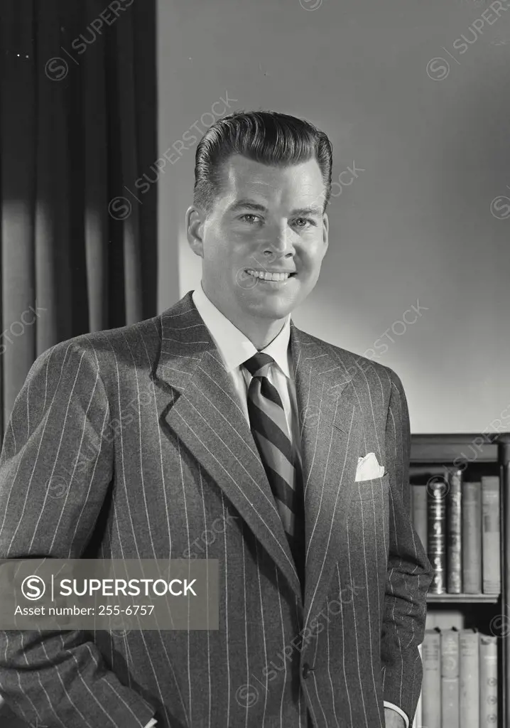 Man in pinstripe suit smiling at camera