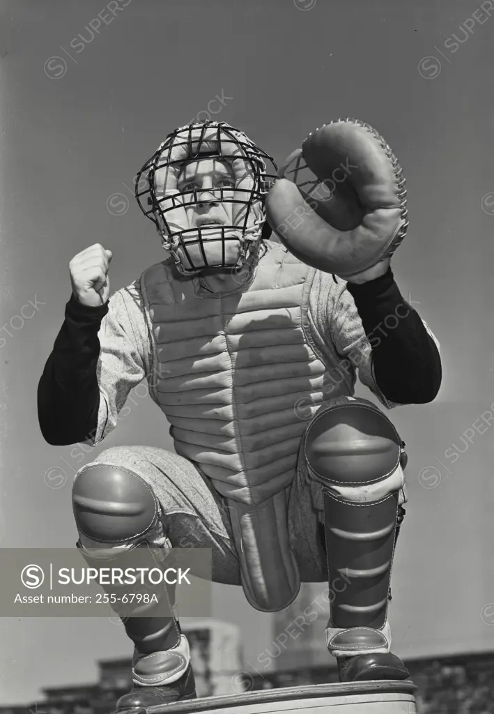 Vintage Photograph. Baseball catcher wearing facemask crouching making hand signal in between legs Frame 1