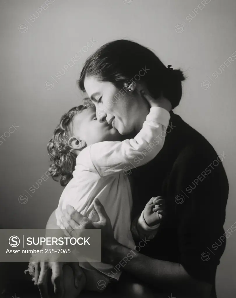 Side profile of a daughter kissing her mother