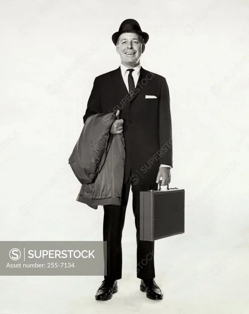 Portrait of a businessman holding a briefcase and an overcoat
