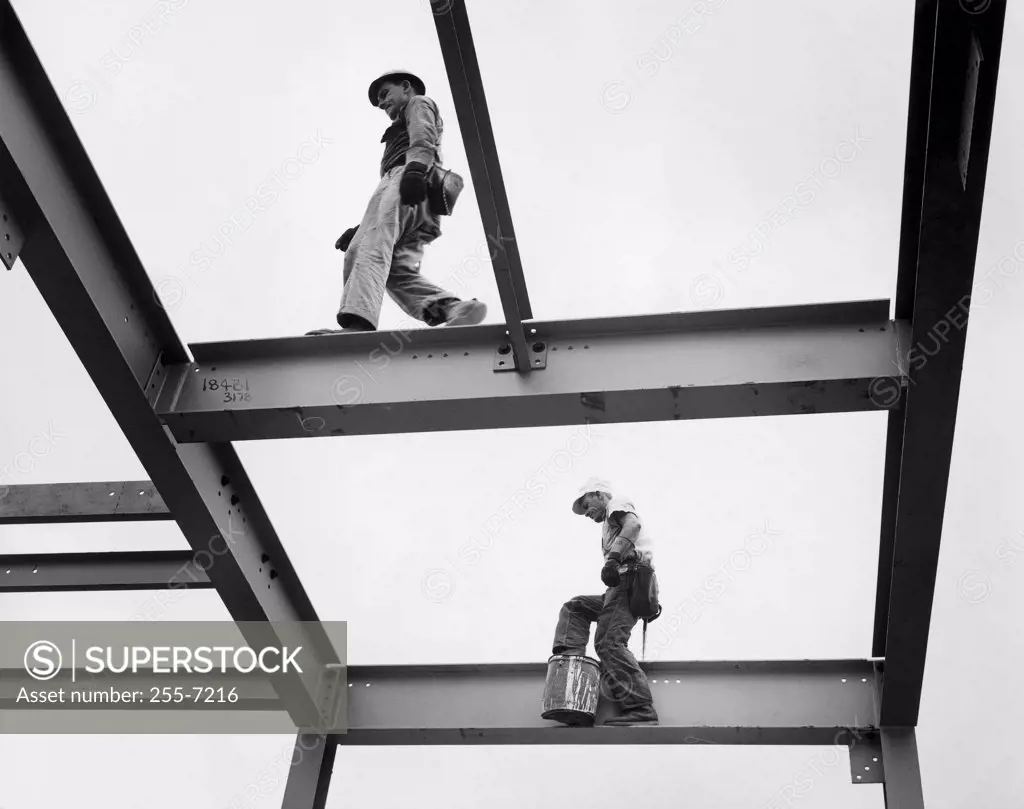 Two construction workers walking on the frame of a grain elevator, New Orleans, Louisiana, USA