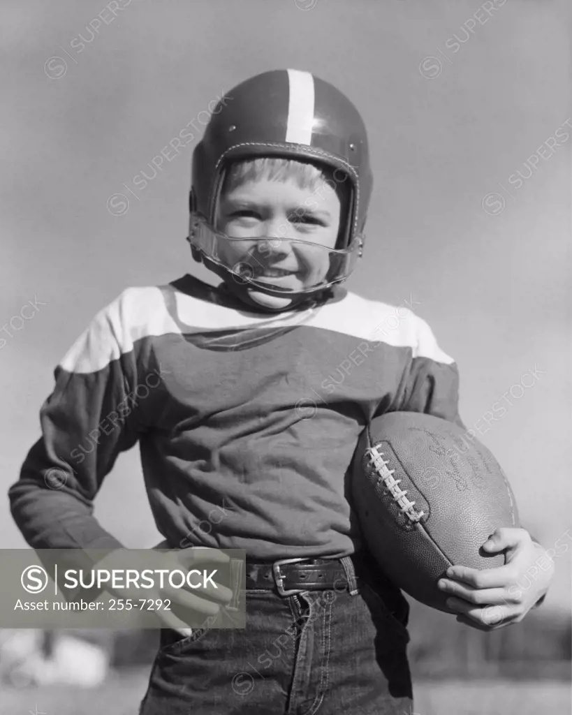 Portrait of boy holding american football