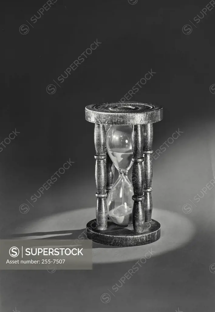 Vintage photograph. Close-up of an hourglass casting shadow