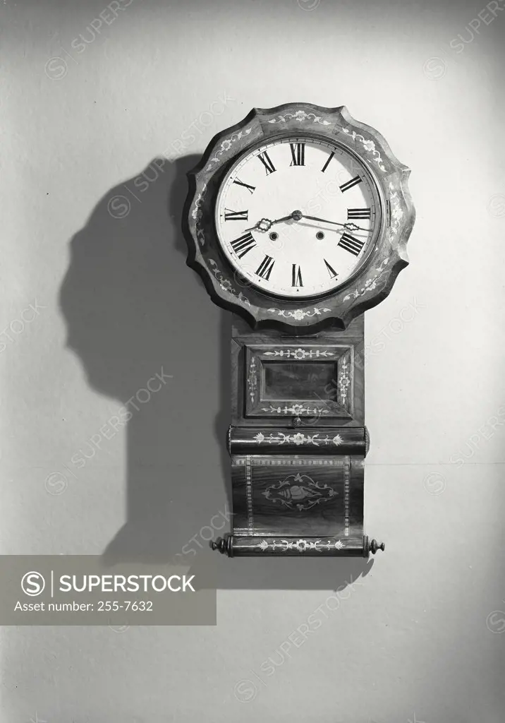 Vintage photograph. Close-up of clock on wall casting shadow