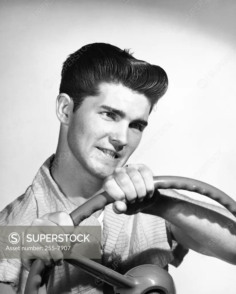 Close-up of a young man holding a steering wheel