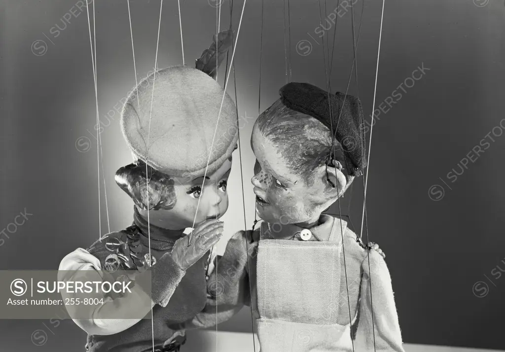 Vintage photograph. Male and female puppets sitting close having a private conversation