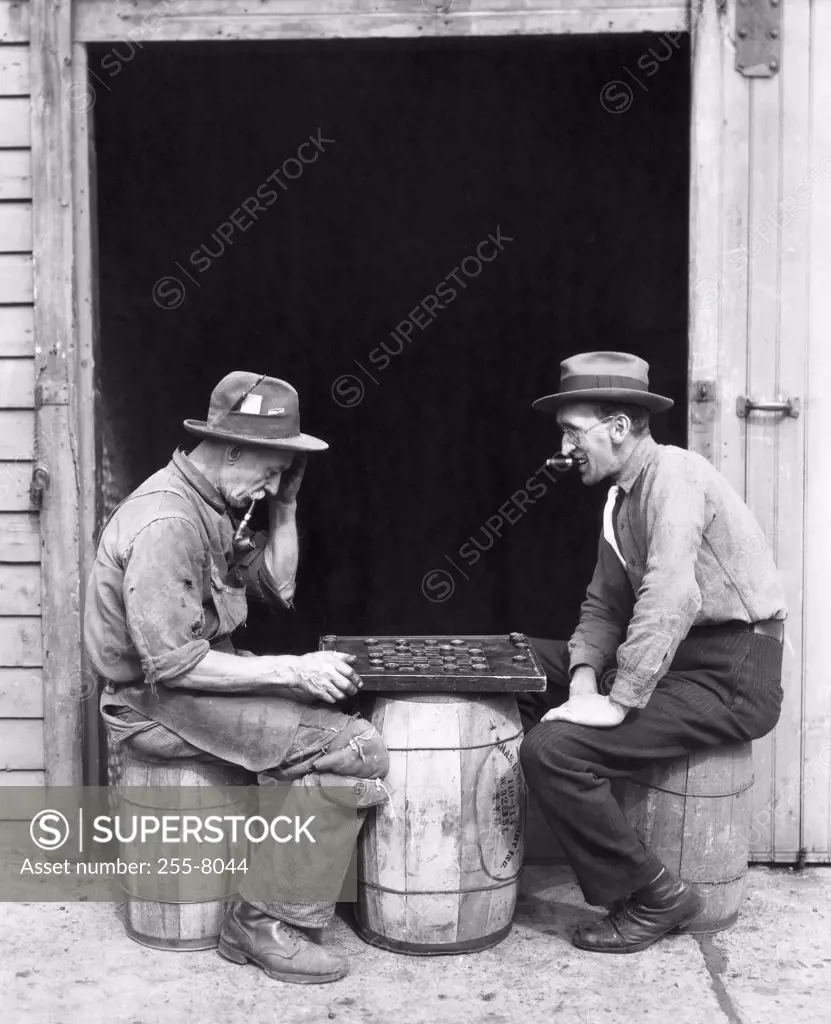 Side profile of two mature men playing checkers