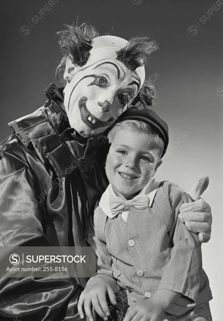 Vintage Photograph. Young boy sitting with man dressed as clown