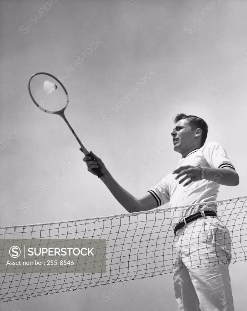 Low angle view of a young man playing badminton