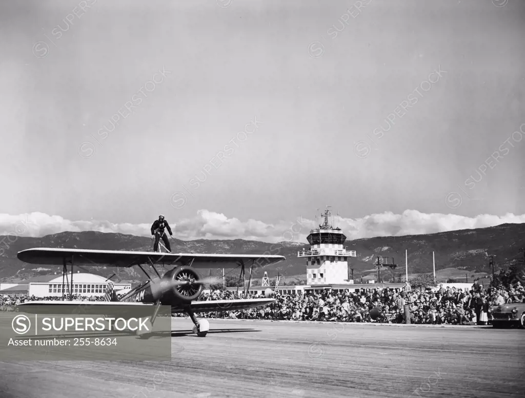 Wing walker standing on top of aircraft