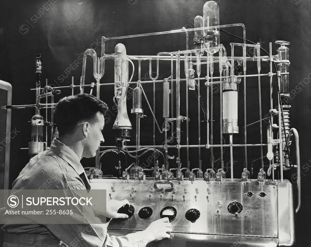 Vintage photograph. Engineer using Vacuum Fusion Gas Analyzer to determine the exact amount of oxygen, hydrogen, and nitrogen in various metals and alloys to aid for clues to better jet engines