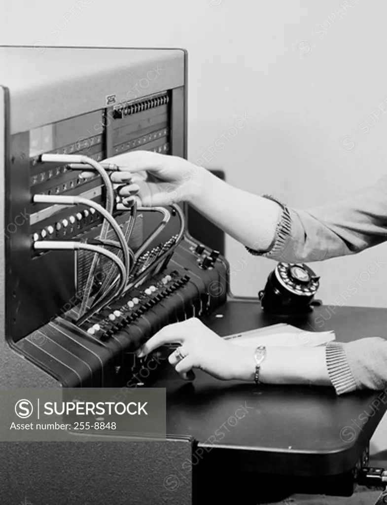 Close-up of a woman's hand operating a telephone switchboard