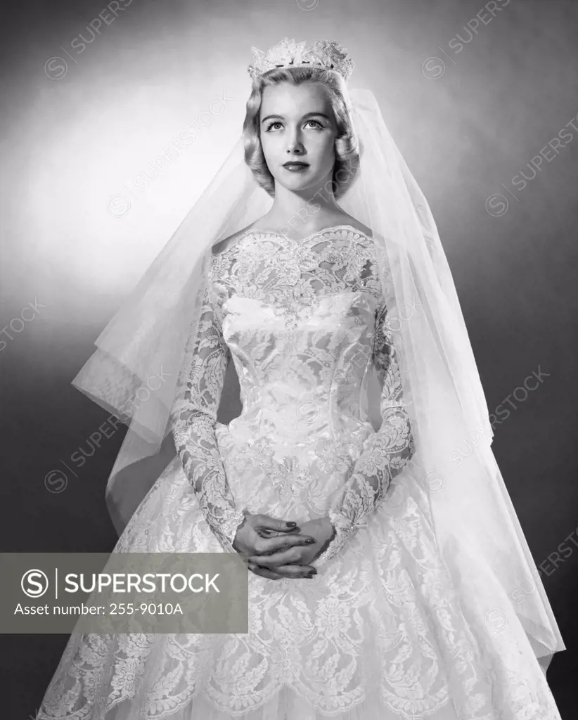 Bride in wedding dress with hands clasped