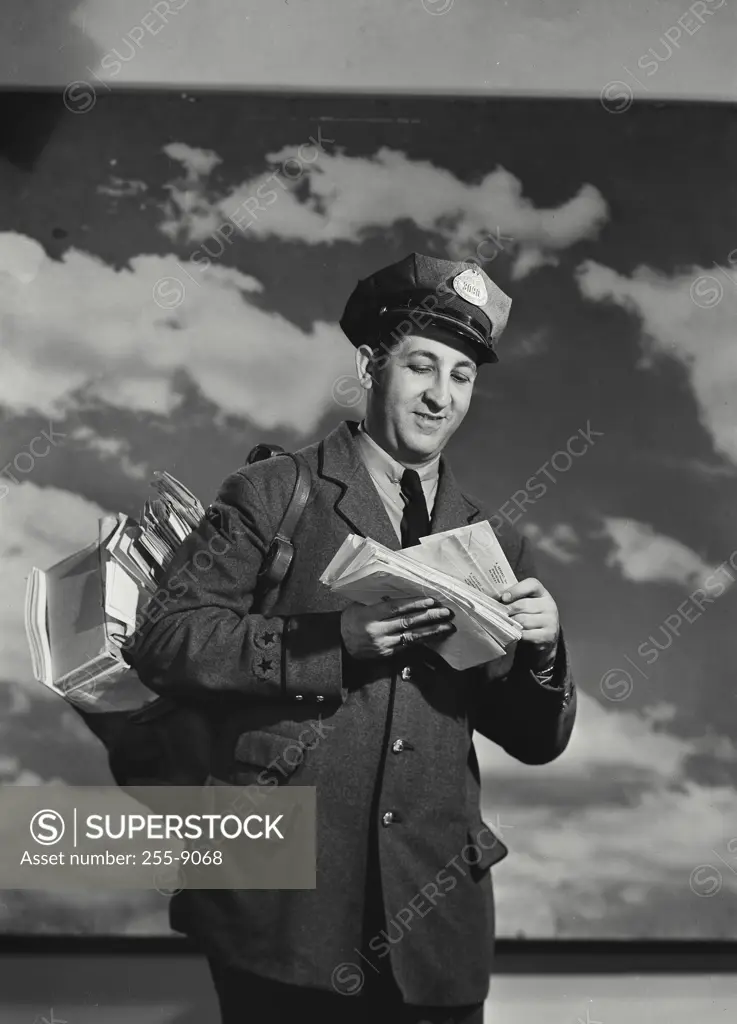 Vintage Photograph. Mailman holding bag of mail and a letter. Frame 3