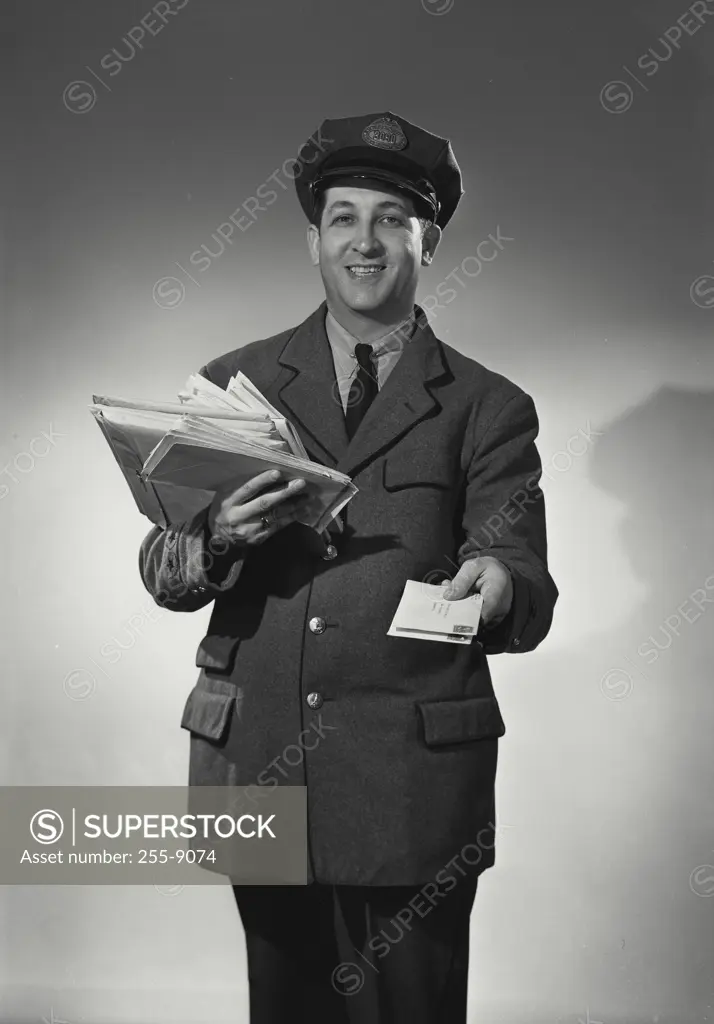 Vintage Photograph. Mailman holding stack of mail and a letter.