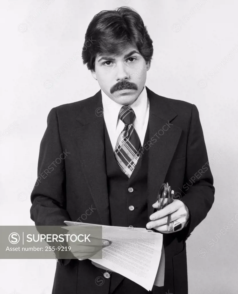 Portrait of a businessman holding documents and a pen