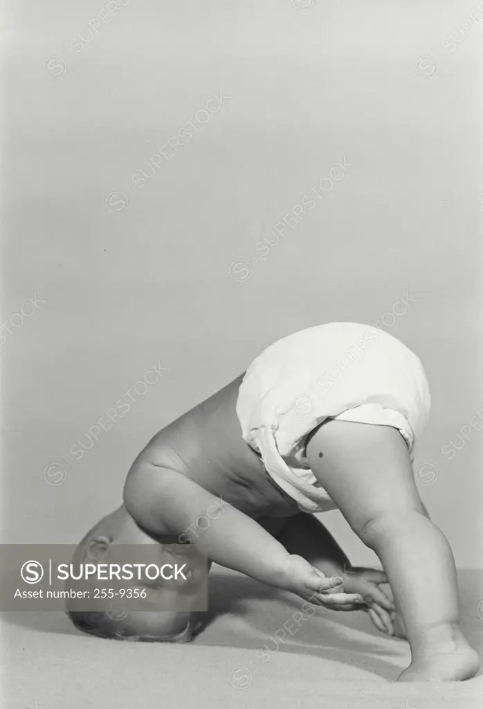 Vintage Photograph. Baby comically leaning upside down on its head