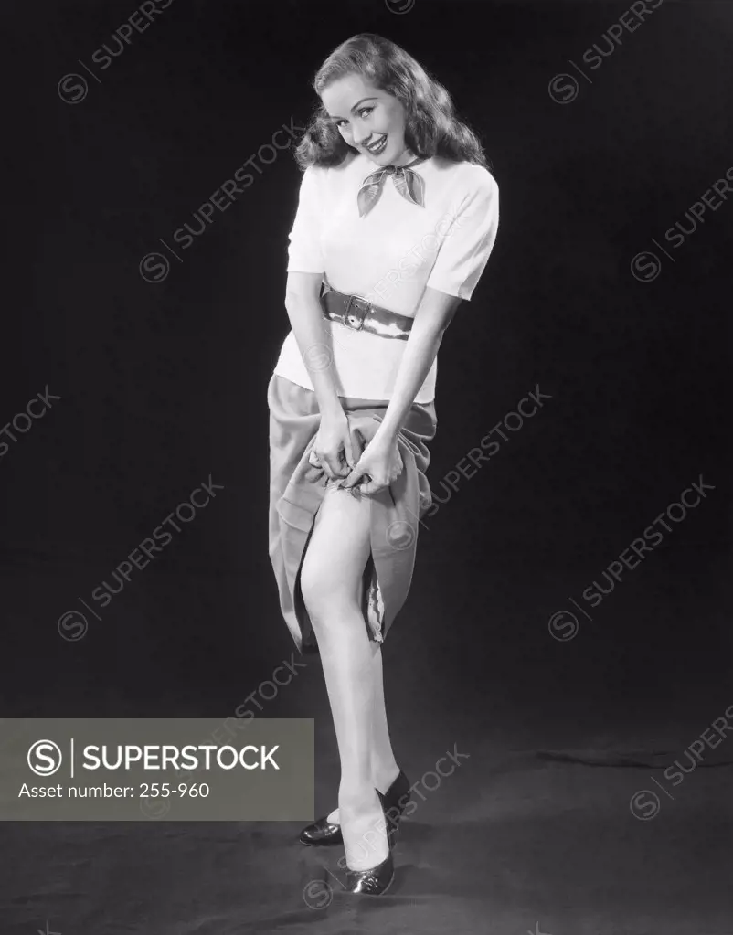 Portrait of a young woman adjusting a garter belt