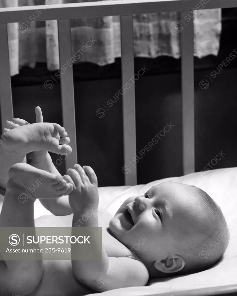 Portrait of cheerful baby with feet up