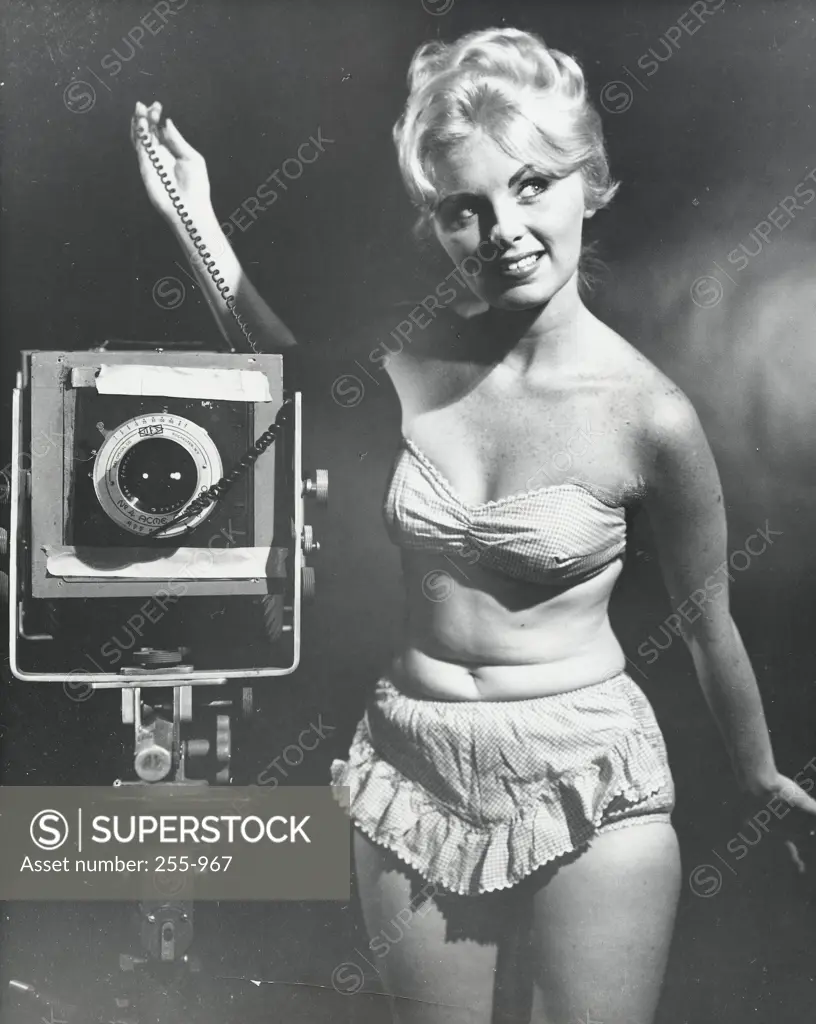 Young woman standing with a camera