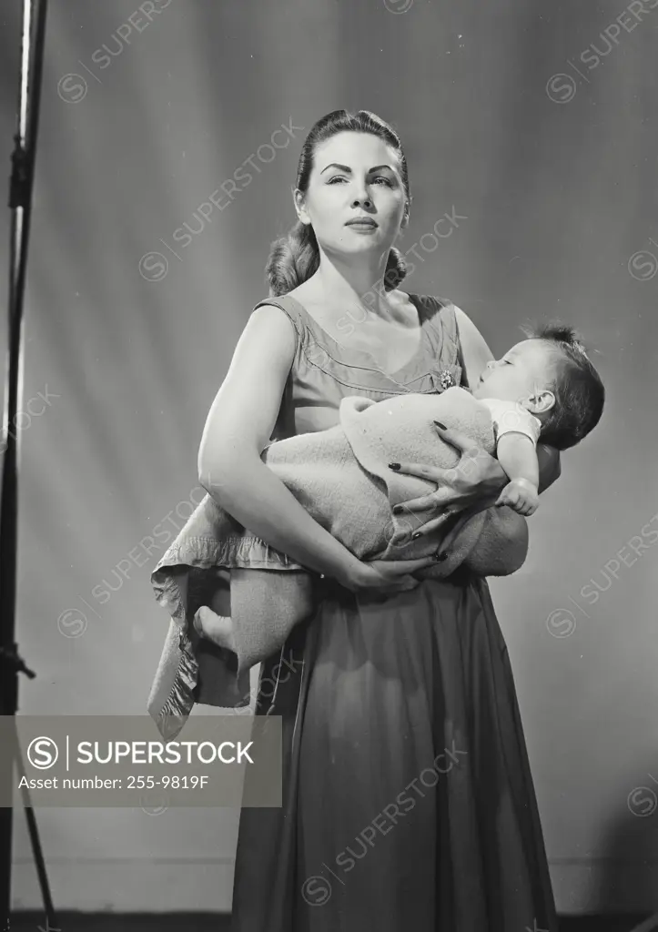 Vintage Photograph. Mother cradling swaddled son in arms